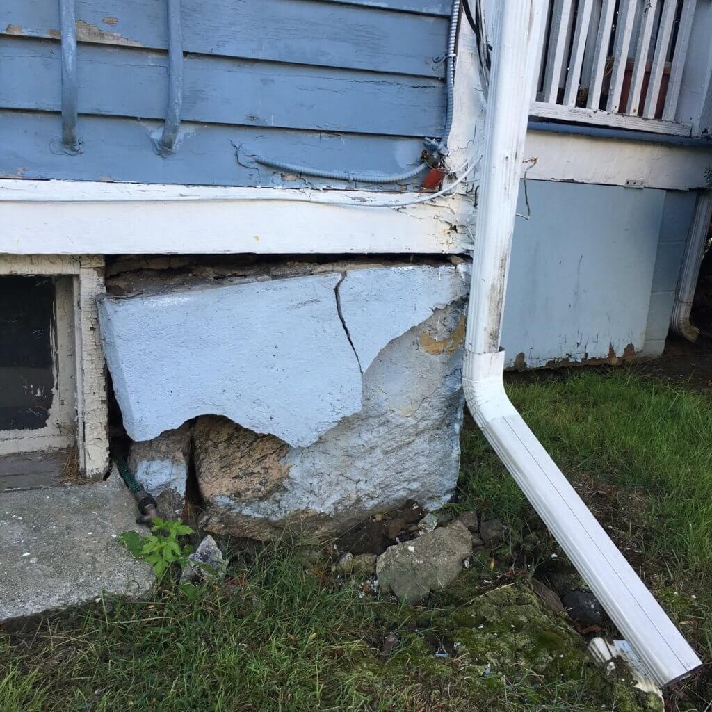 House with cracks and holes in foundation that pests can get through.