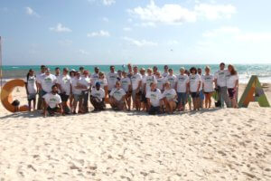 Gunter employees posing at the beach during Gunter's Mexico retreat.