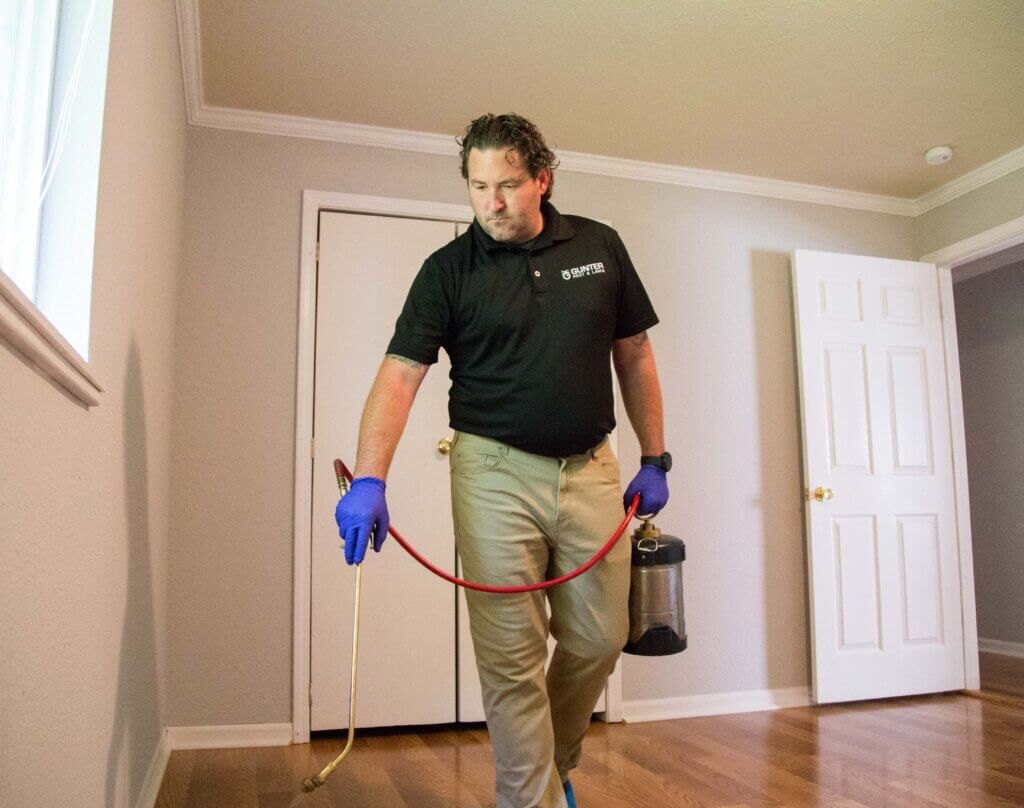 Gunter Pest & Lawn employee spraying for pests in a new apartment.